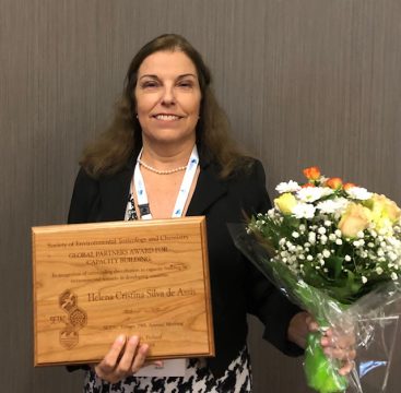 Professora Helena com a placa de premiação